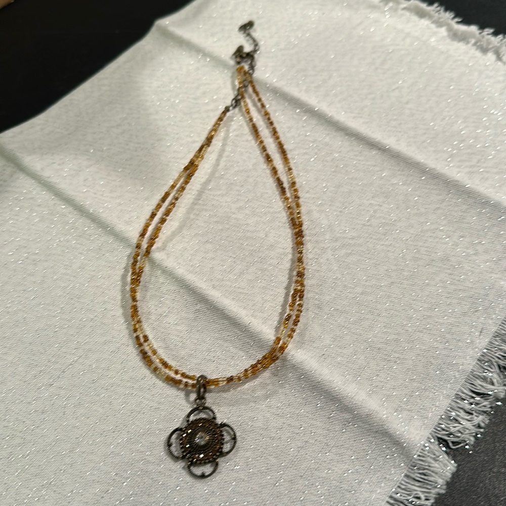 Tan beaded necklace with handing charm